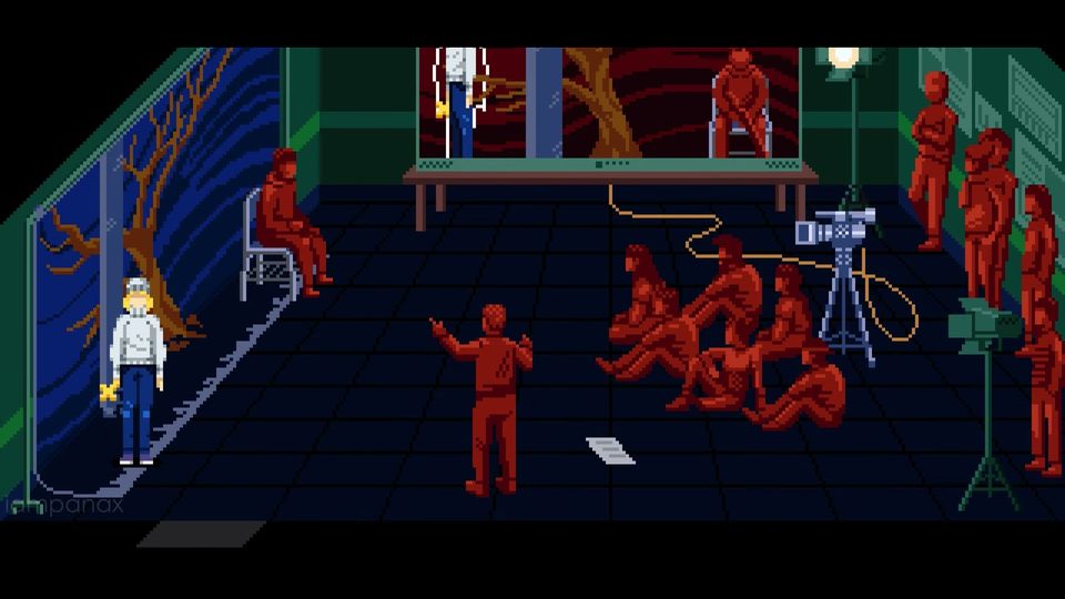 Classroom full of red seated and standing statues; the monitor at the back shows Julia inside a white outline and a camera on a tripod stands on the right